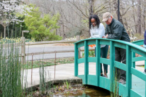 Tony stands with Hannah Huff, who works at the CARE Center, on a bridge in the Botanical Garden. 